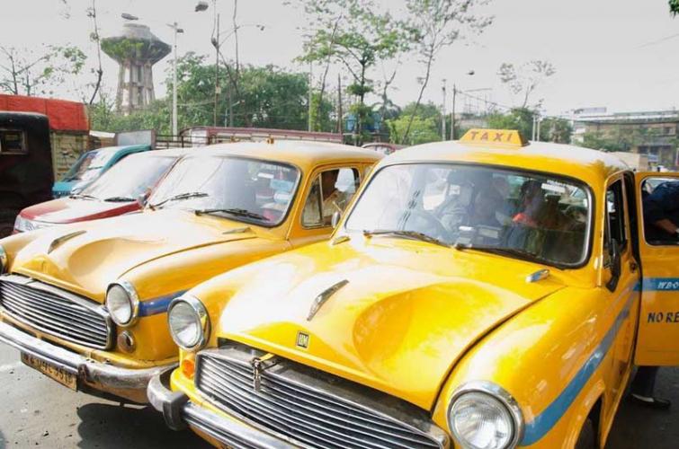 Yellow cabs stand idle on a sunny day in Kolkata, India. They once dominated the market in India, but when ride sharing services like Uber pierced through the South Asian market, their business has been threatened. (Photo by Suryodoy Mondol)