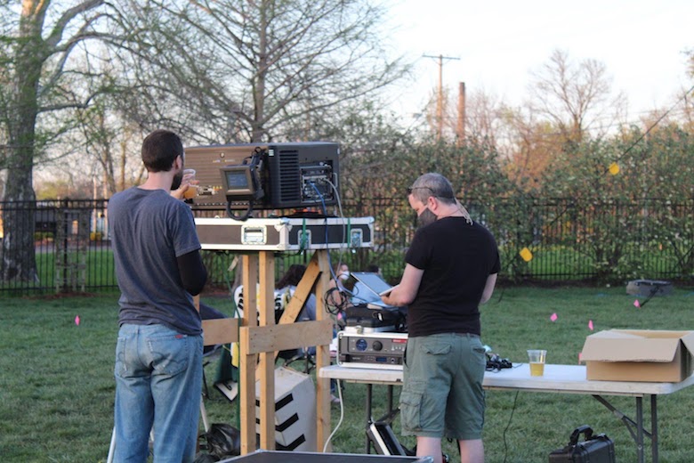 Two projectionists set up the projector for an outdoor screening April 11 at Logboat Brewing Company in Columbia. Logboat uses a 300 lb blow-up screen to show movies outside.