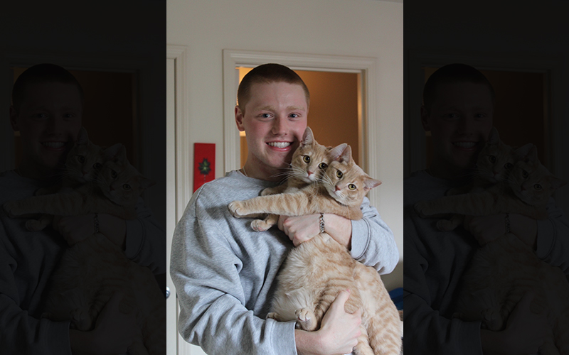 Eli Bolding holds his two cats, Tax Fraud and Ponzi Scheme, on Wednesday, April 5, 2023, in Columbia. Bolding adopted his cats during the COVID-19 pandemic. (Photo by Zeyu Wang)