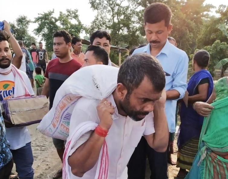 Assam flood: Congress MLA seen carrying relief materials on his back