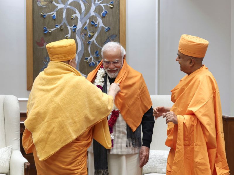 PM Modi is traditionally adorned with a shawl and garland by Pujya Swami Ishwarcharandas, Swami Brahmaviharidas | Photo courtesy: baps.org