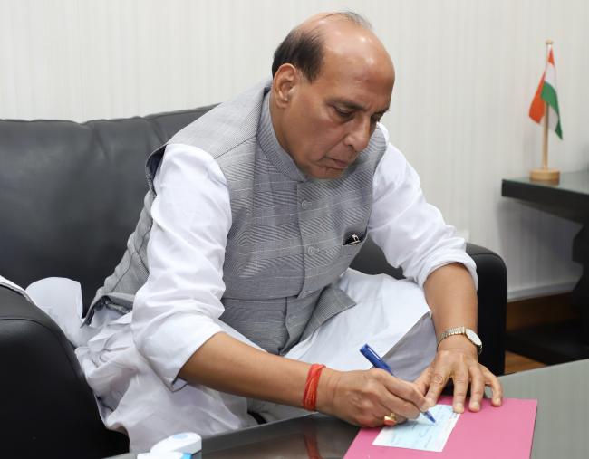 Rajnath Singh presenting a cheque to the Union Home Secretary
