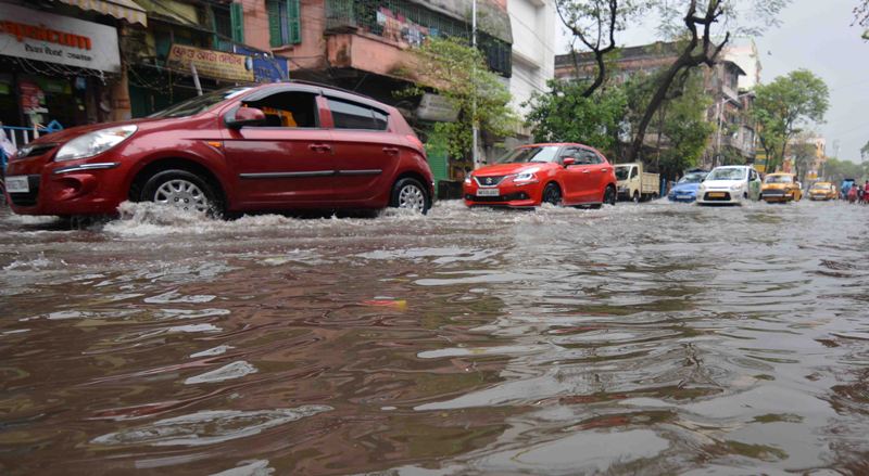 Rickshaw puller wades through water-logged street in Kolkata
