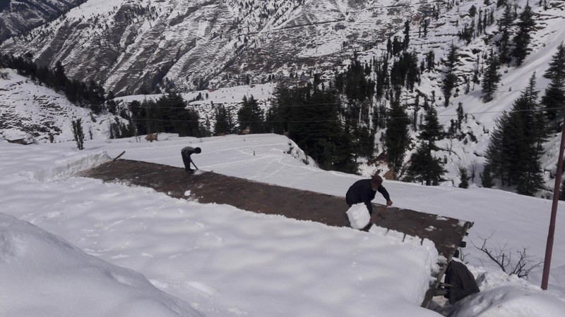 People walk through snow covered Bhaderwah-Chamba inter-state road in Kashmir