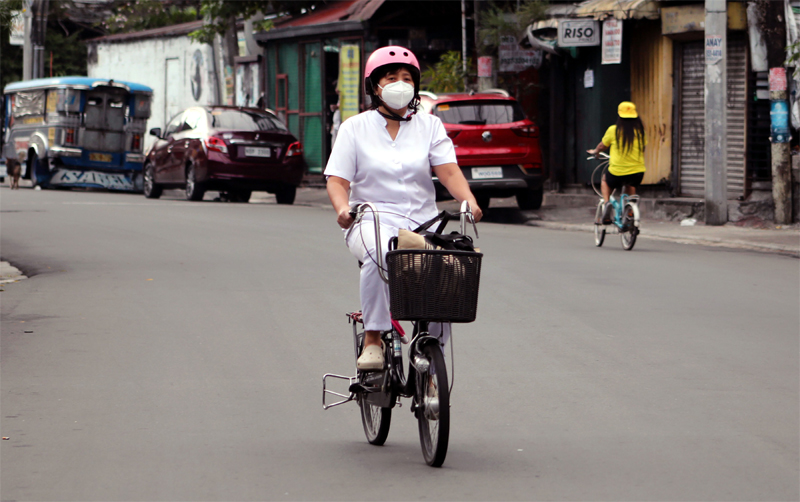 Worker rides bicycle in Phiippines