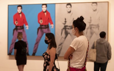 Visitors view artwork at an exhibition in London as galleries reopened after Covid-19 lockdown