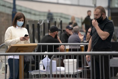 A woman uses the track and trace app at a pub in Manchester