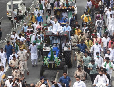 Patna: RJD leader Tejaswi Yadav driving a tractor as supporters raising slogans during Bharat Bandh