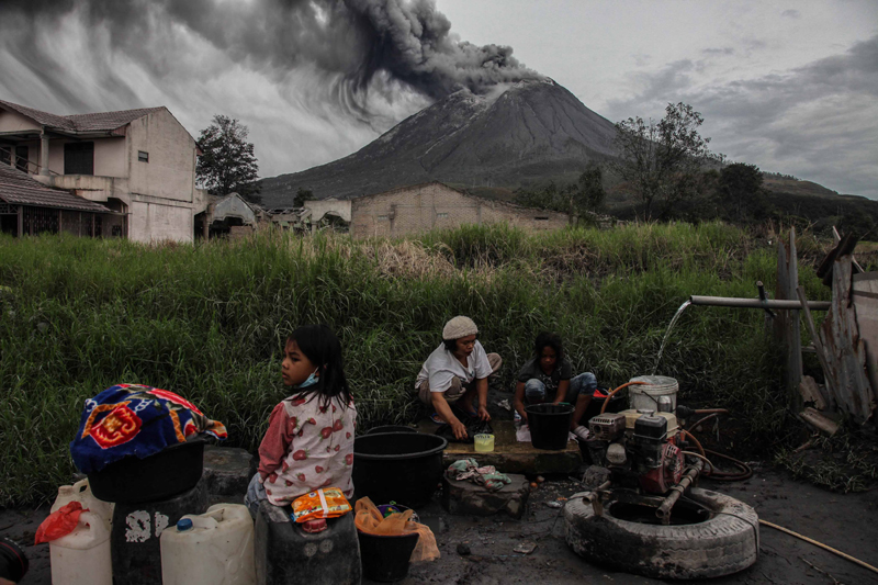 Indonesia: People wash their clothes as Mount Sinabung