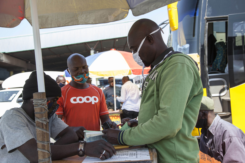 A passenger buys ticket for his trip at an intercity bus terminus in Lusaka