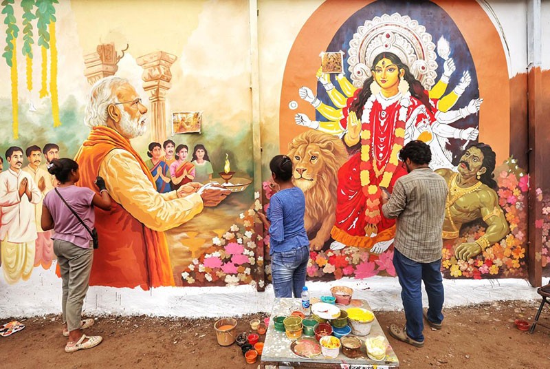 In Images: Kolkata’s Chorebagan Sarbojonin unveils wall painting of PM Modi performing aarti to Goddess Durga