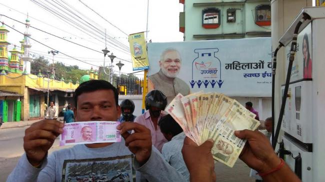 People stand in queue to exchange currency notes