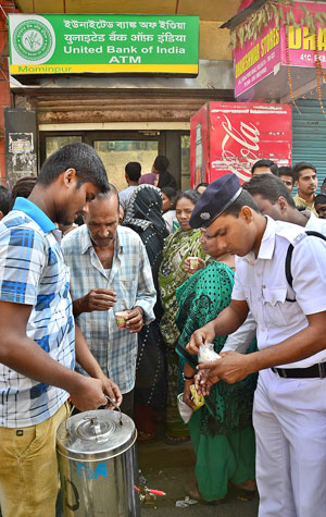 Kolkata: People queue in front of banks, ATMs to get cash