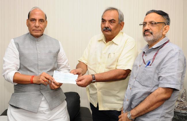 Rajnath Singh presenting a cheque to the Union Home Secretary