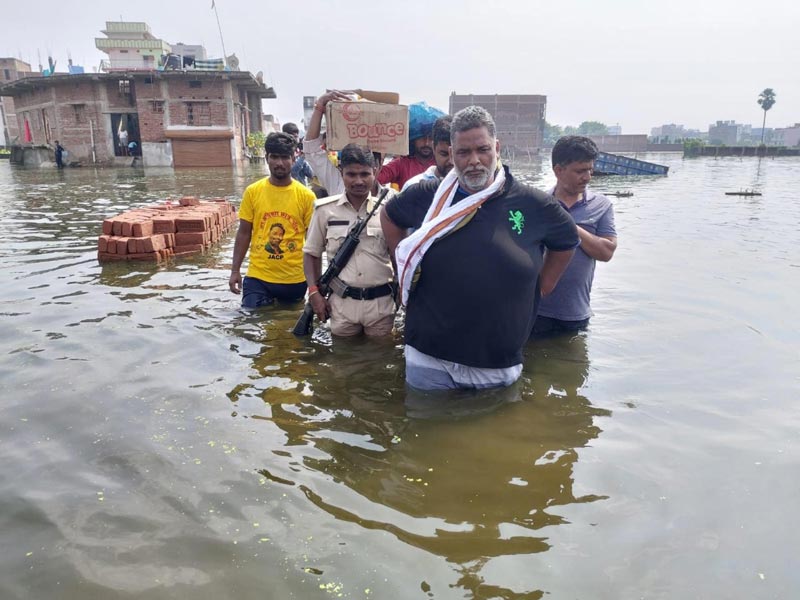 Jan Adhikar Party Chief Pappu Yadav wade through a flooded area