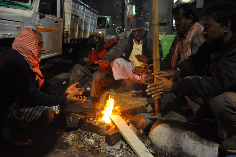 People warm up before fire to fight cold in Kolkata 