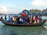 Hindu devotees immerse Durga Goddess into a river in Dhaka