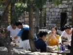 Tourists rest in a yard of a homestay in Xijingyu Village