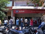 Customers maintain social distancing outside bank in New Delhi