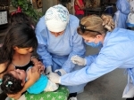 Syria: Medical workers give a vaccine to a child