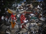 Nepalese women decked up in traditional attires feeding pigeons on Teej