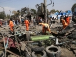 Afghan municipal employees work at the site of a bomb attack in Kabul