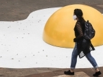 Pedestrian wearing mask walks by artwork in Sao Paolo