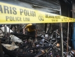 Indonesia: A resident looks for his belongings from a charred house