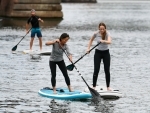 Frankfurt: Standup paddle boarding enthusiasts exercise on Main