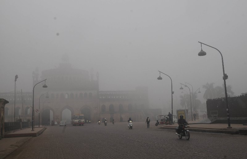A man cycles in a fog covered morning in Lucknow