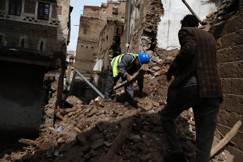 Sanaa:Workers remove rubbles from the ruins of a historic building