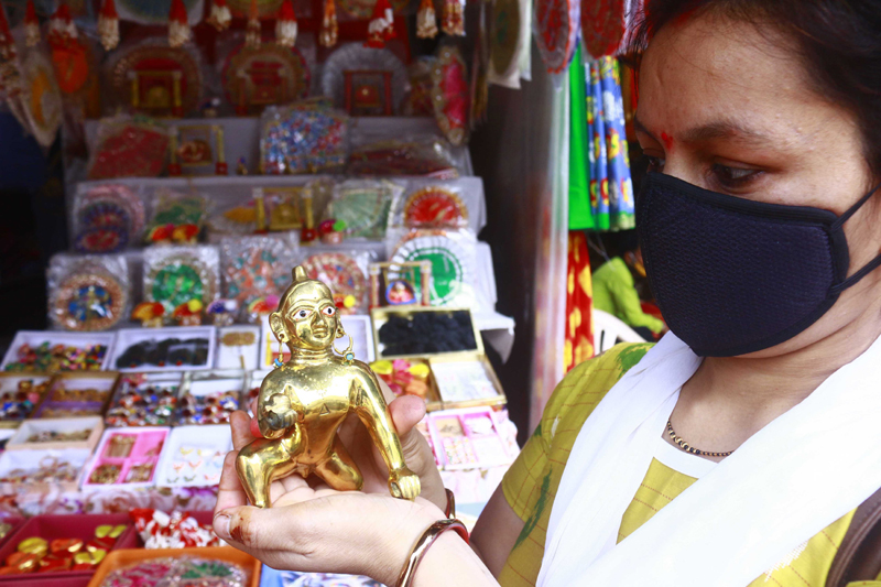 A woman buying a Lord Krishna idol ahead of Janmanstami