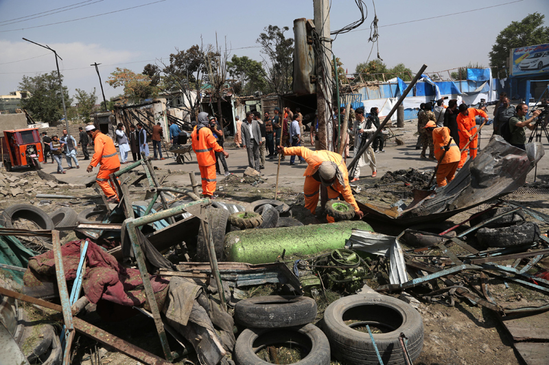Afghan municipal employees work at the site of a bomb attack in Kabul