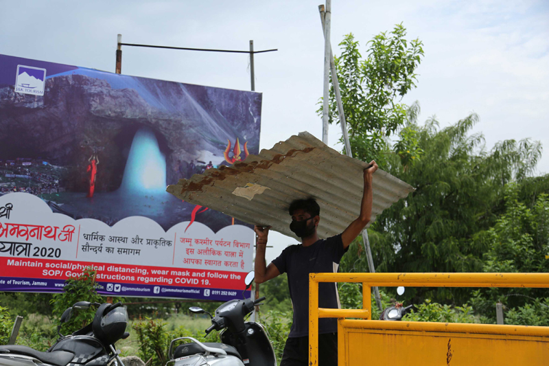 Labourer removes metal sheets from Yatri Niwas in Jammu after Amarnath Yatra cancelled