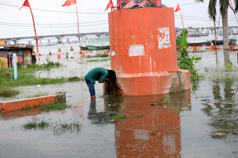 Man drinks water from submerged floodwater of Ganga in Prayagraj