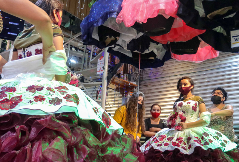 People with masks shop in a store in Mexico City