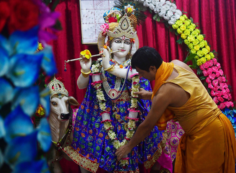 Janmasthami: A priest arranging the dress and ornaments of Lord Krishna