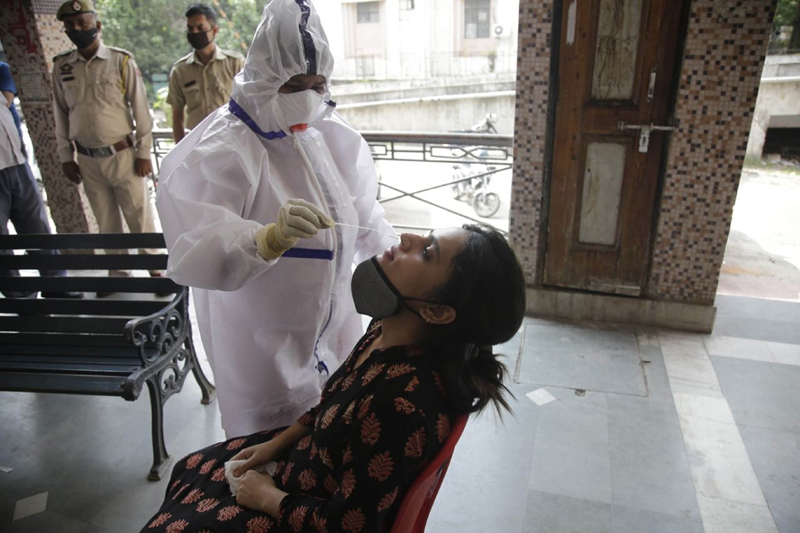 Health staff taking nasal swab on woman in Jammu