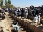 People digging graves for victims of a suicide explosion in Afghanistan's Kandahar city