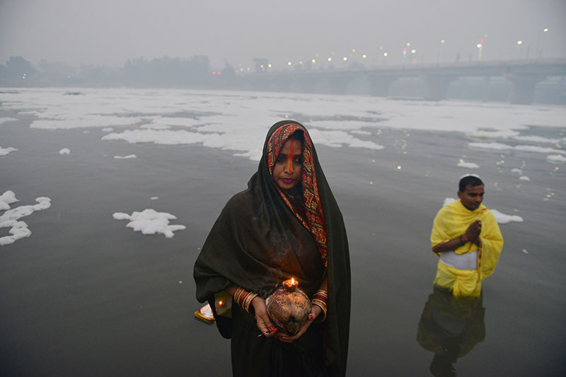 Devotees worship the rising sun at the banks of Yamuna in Delhi