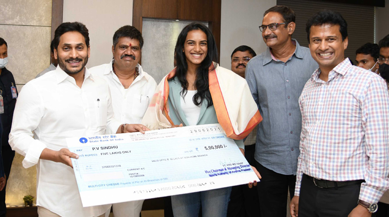 Andhra CM Y S Jagan Mohan Reddy presenting Rs.5 lakh cheque to P V Sindhu