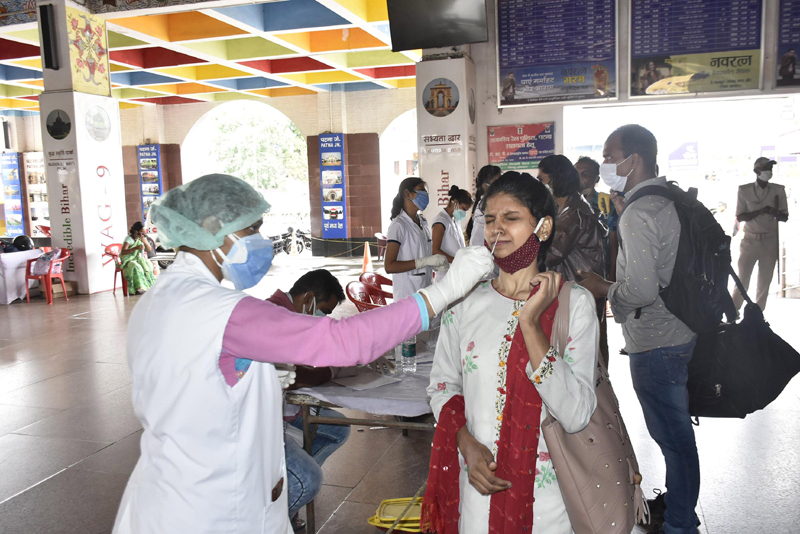 Health workers collect Covid-19 test swabs of Maharashtra returnees at Patna station