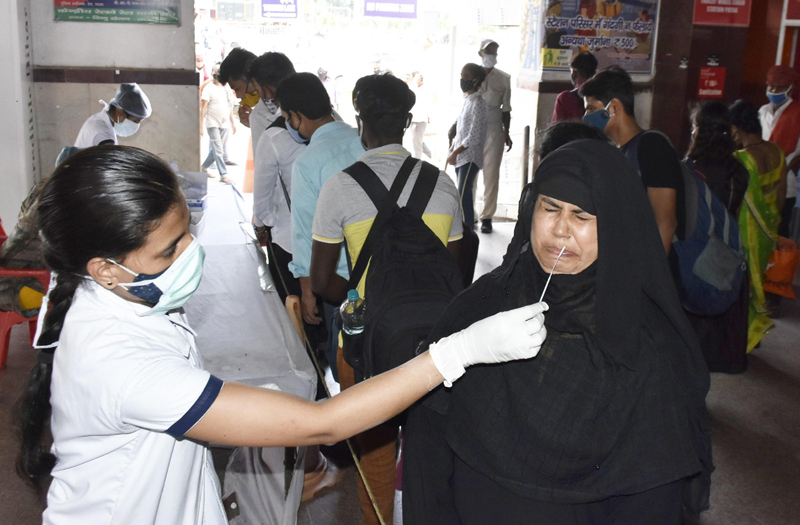 Health workers collect swab samples of passengers at Patna railway station
