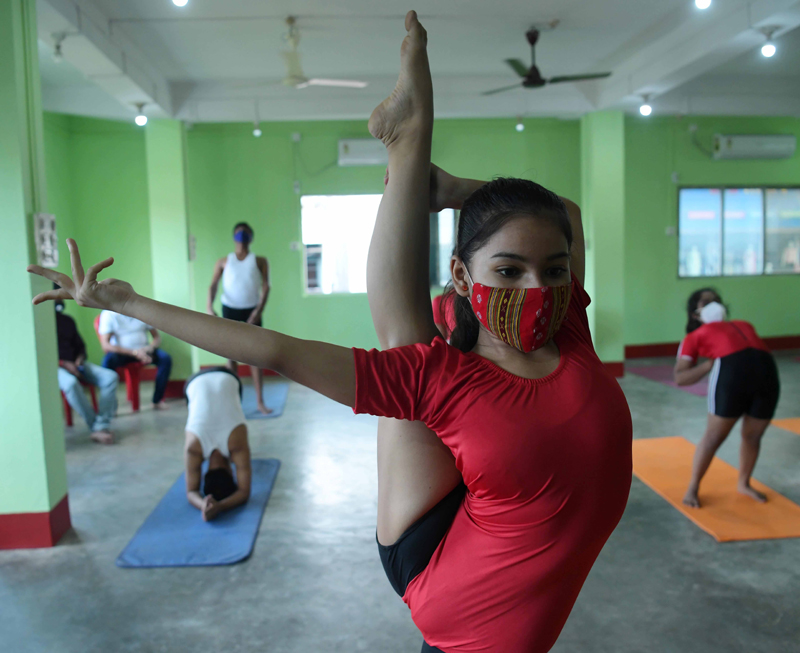 Students and volunteers of Tripura Yoga Association perform yoga