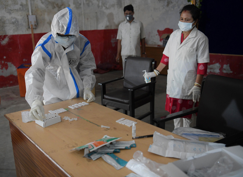 Health worker in PPE kit checking swabs for Covid-19 in Tripura