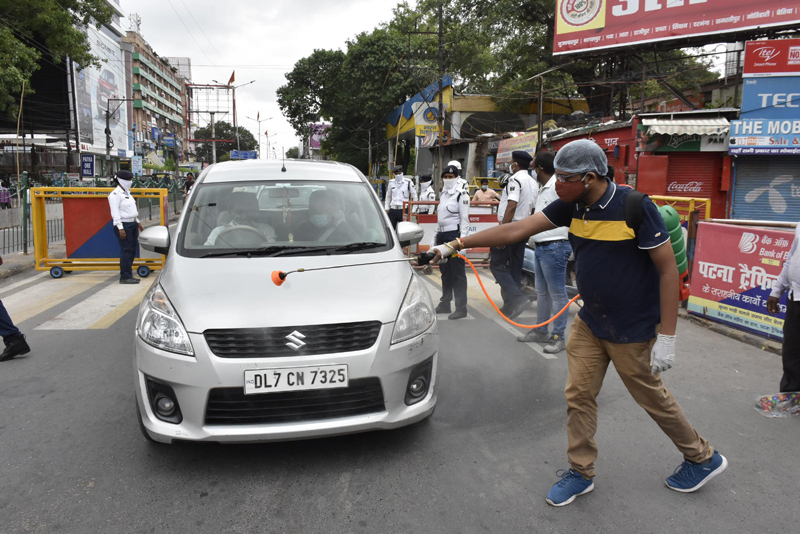 Volunteer sprays disinfectant on vehicles in Patna