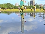 Boys play football in Kolkata's rain-washed urban park