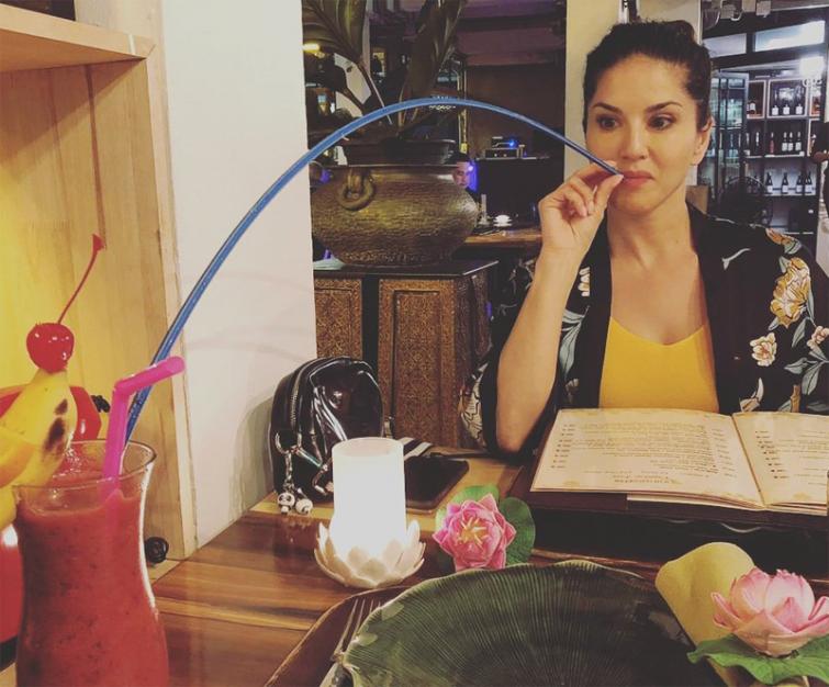 Sunny Leone shows her unique fashion of drinking juice with a long pipe