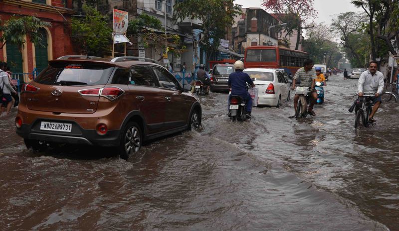 Rickshaw puller wades through water-logged street in Kolkata