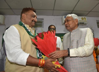 Nitish Kumar presents bouquet to social worker Narendra Singh on his joining JD(U)